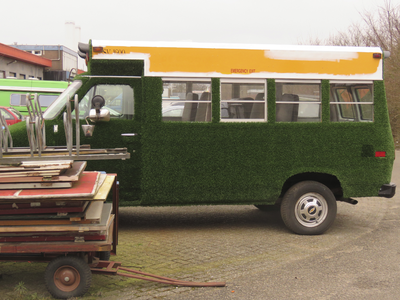 908183 Afbeelding van een personenbusje dat bekleed is met kunstgras, geparkeerd bij het voormalige Bodencentrum aan de ...